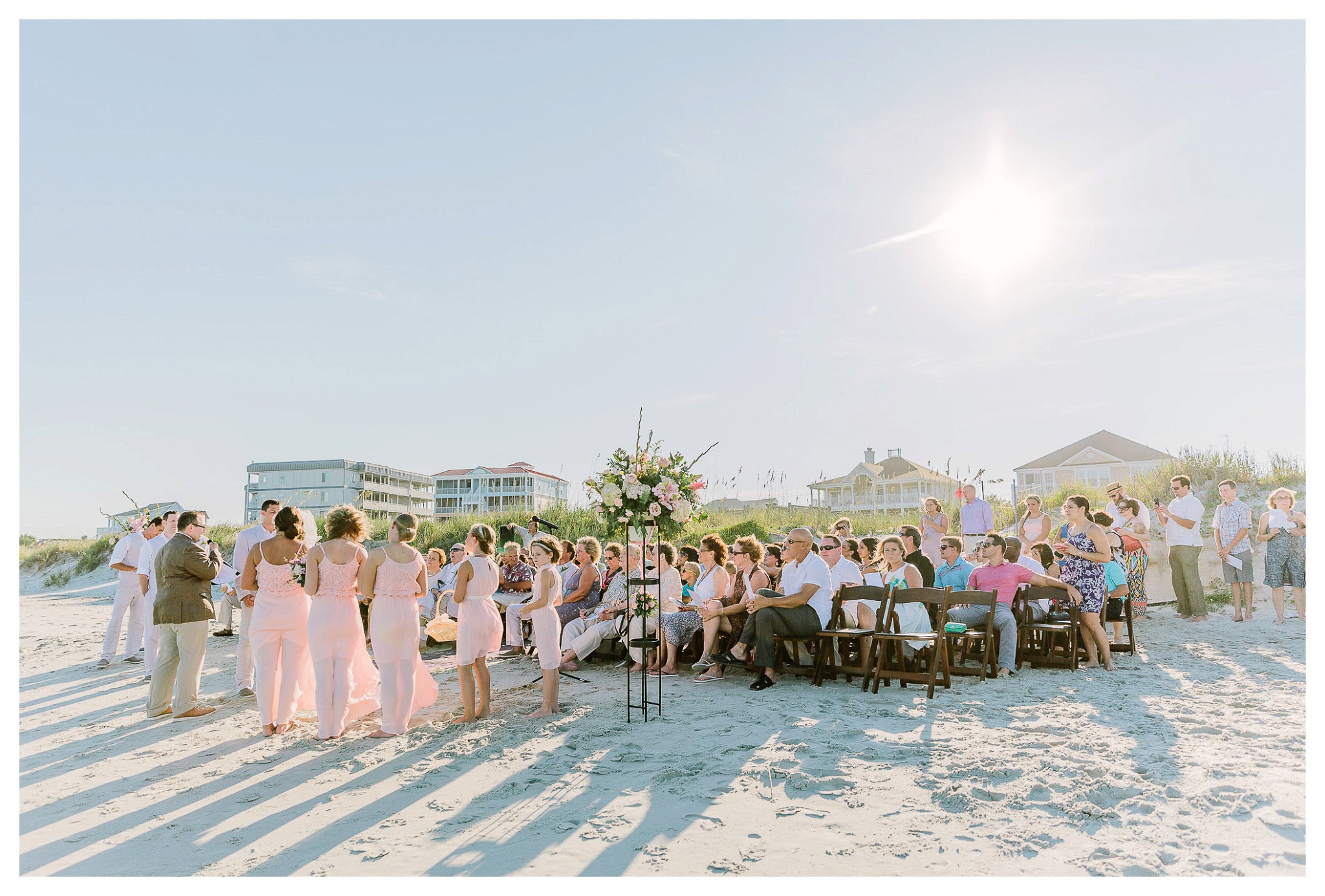 A picture from the water, toward the wedding and guests on the sand - Venue - Beach House Gulf Stream Breeze, Beach Realty Catering and Cake - Buttercream Cakes and Catering, LLC Flowers - Callas Florist Event Rentals - Event Works DJ - Scott Shaw