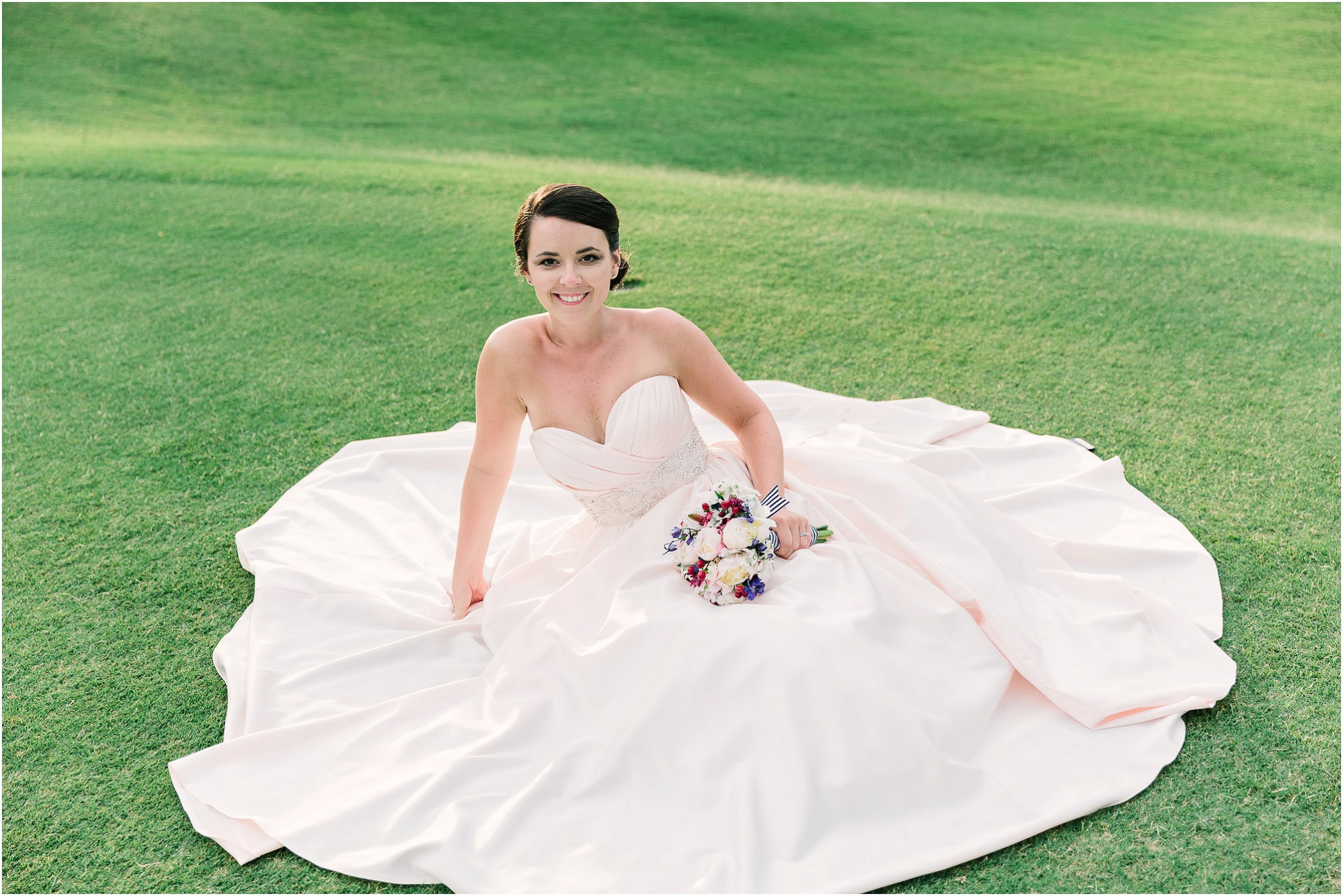 The brides dress spread across the grass like a large lilly 