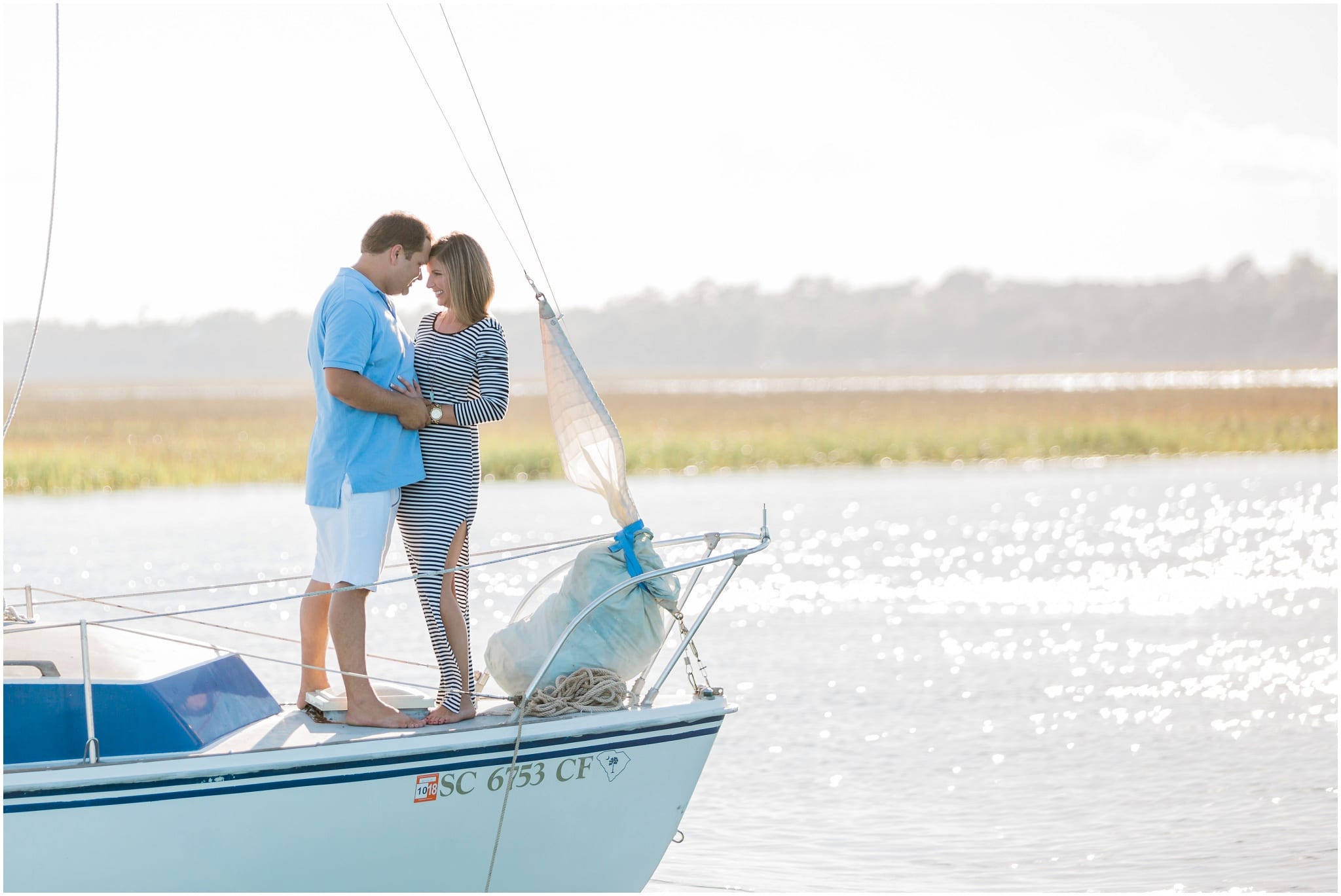 Engagement session on a sail boat, Dana and Bradley embracing on the bow, Sailing, Myrtle Beach Engagement Photography Session 8, Murrells Inlet, South Carolina, www.onelifephoto.net Photography