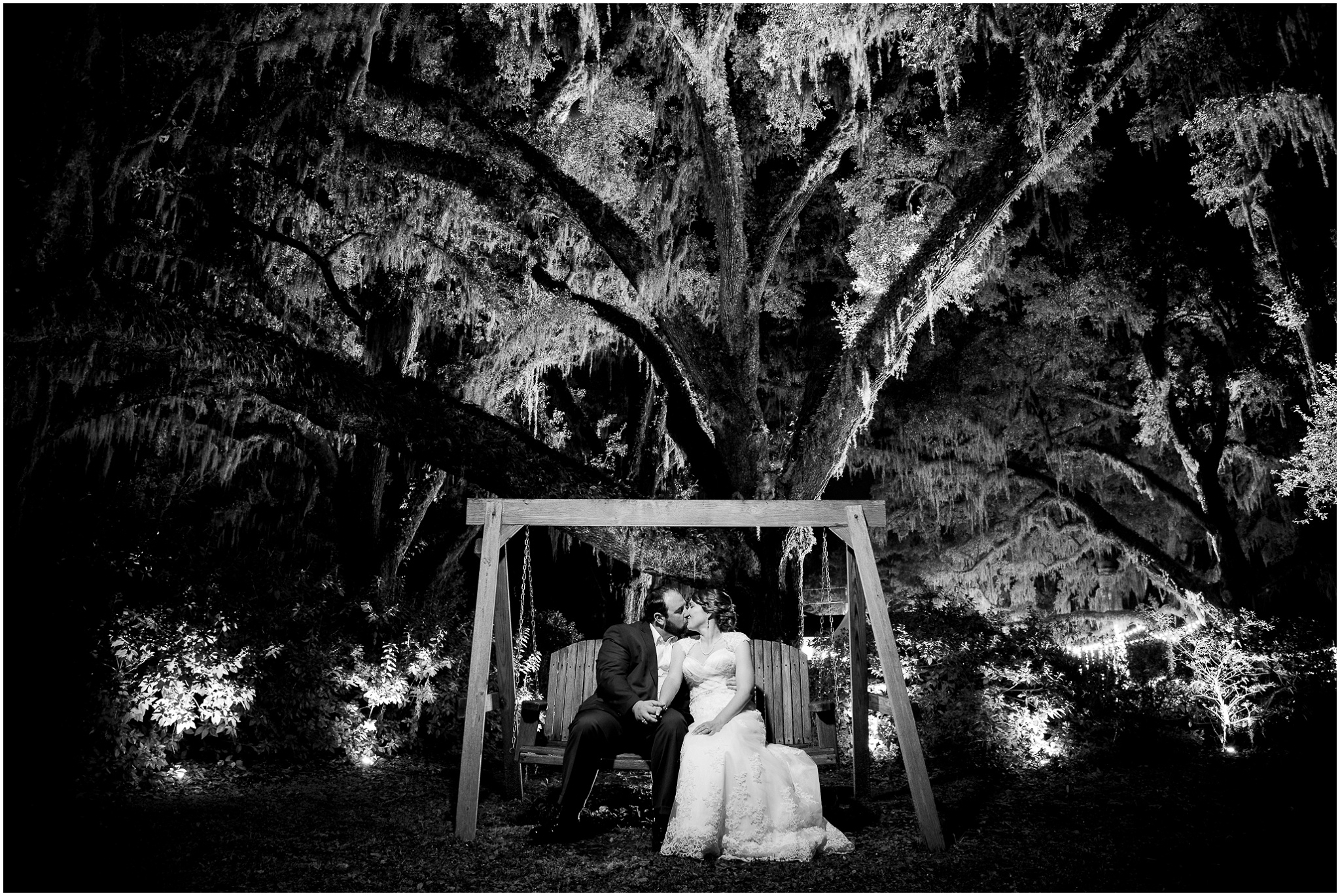 Paige and Dorsey lit up in the dark on the wing under the giant willow in Black and White, Upper Mill Plantation Wedding Session 33, Conway, South Carolina, Wedding coordinator, flowers and Cake - Willow Event Designs, Venue - Upper Mill Plantation, DJ - Carolina Entertainment, Dress - Foxy Lady, www.onelifephoto.net Photography