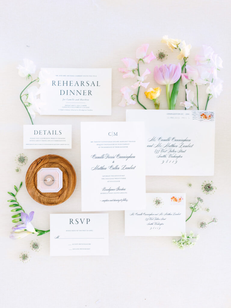 Flat lay invitations and details with rings