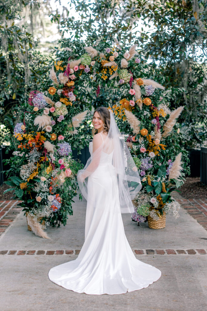 bride in front of the floral arch