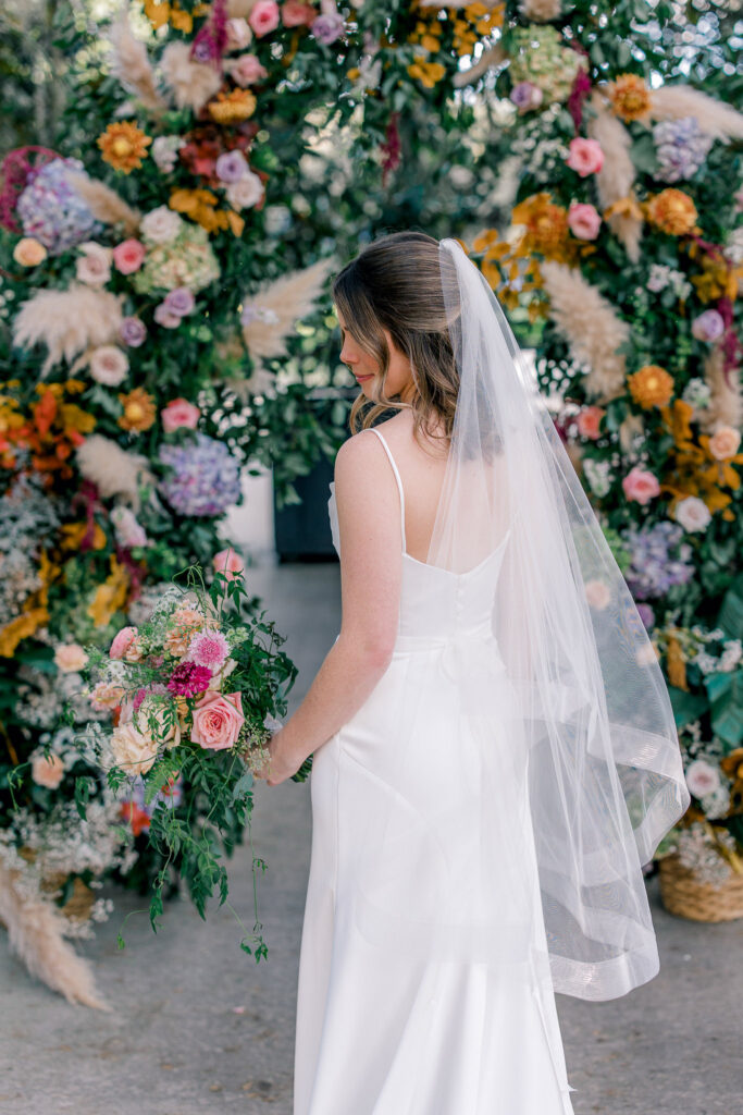 Bride in front of the floral arch